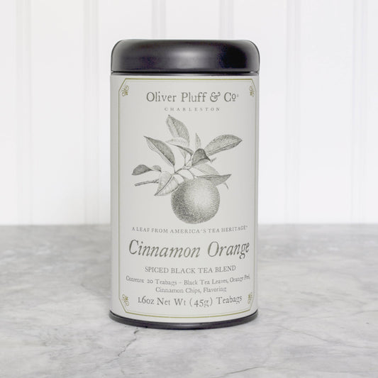Tea canister labeled 'Cinnamon Orange' by Oliver Pluff & Co on a marble surface with a white background.