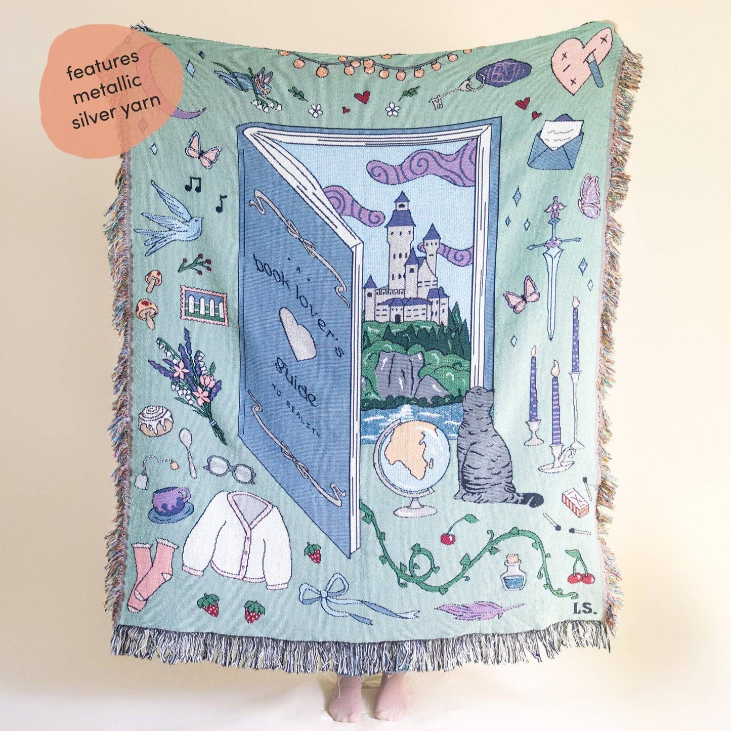 Decorative blanket with illustrations of a book, castle, and various objects on a light blue background. Book lover blanket 