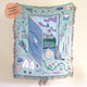 Decorative blanket with illustrations of a book, castle, and various objects on a light blue background. Book lover blanket 